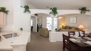 Una sala de estar moderna con comedor, cocina y vista a la calle.