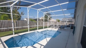 Una piscina cubierta al aire libre con una cerca de madera al fondo.