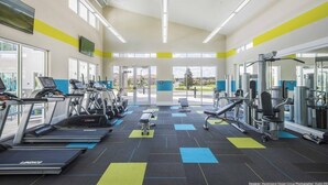Une salle de sport moderne équipée de tapis de course, d’appareils de musculation et de tapis d’exercice.
