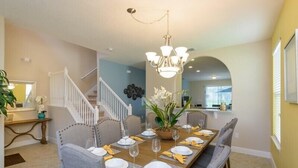 A dining area with a long wooden table set for six, surrounded by grey upholstered chairs. - Fv61774 - Solterra Resort - 5 Bed 4.5 Baths Villa (Davenport)