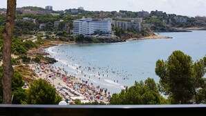 Ein Küstenstrand mit Blick auf eine Stadt am Horizont.
