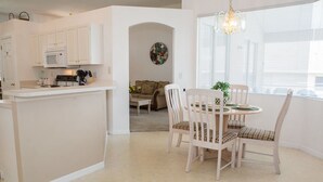 A kitchen with white cabinets, a microwave, and a dining area with a round table and chairs. - Ip60569 - Westridge - 5 Bed 3 Baths Villa (Davenport)