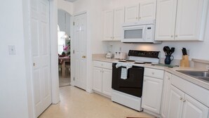 A kitchen with white cabinets, a microwave, an oven, and a sink. - Ip60569 - Westridge - 5 Bed 3 Baths Villa (Davenport)