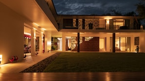 Een modern huis met twee verdiepingen, een ruim buitengebied en een goed verlichte entree.