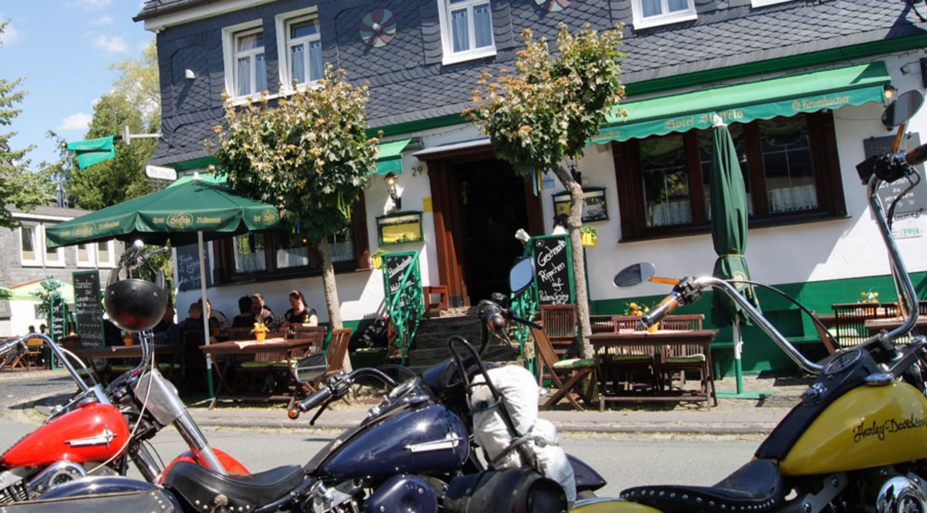 A building with a green awning and outdoor seating area.