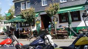 A building with a green awning and outdoor seating area.