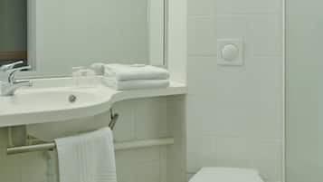 A bathroom with a sink, mirror, towel rack, and toilet.