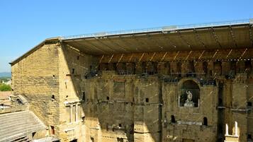 Un vaste amphithéâtre historique en pierre, doté de gradins et d’une scène centrale.