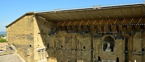 A large, historic stone amphitheater with tiered seating and a central stage area.