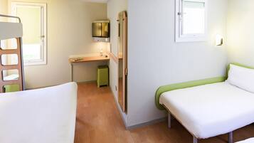A compact hotel room with two single beds, a small desk, a television, and a window.