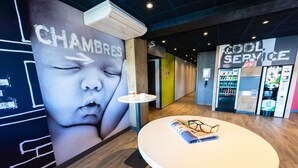 Un interior moderno con aire acondicionado de pared, una mesa con material de lectura y una máquina expendedora que dice 'COOL SERVICE'.