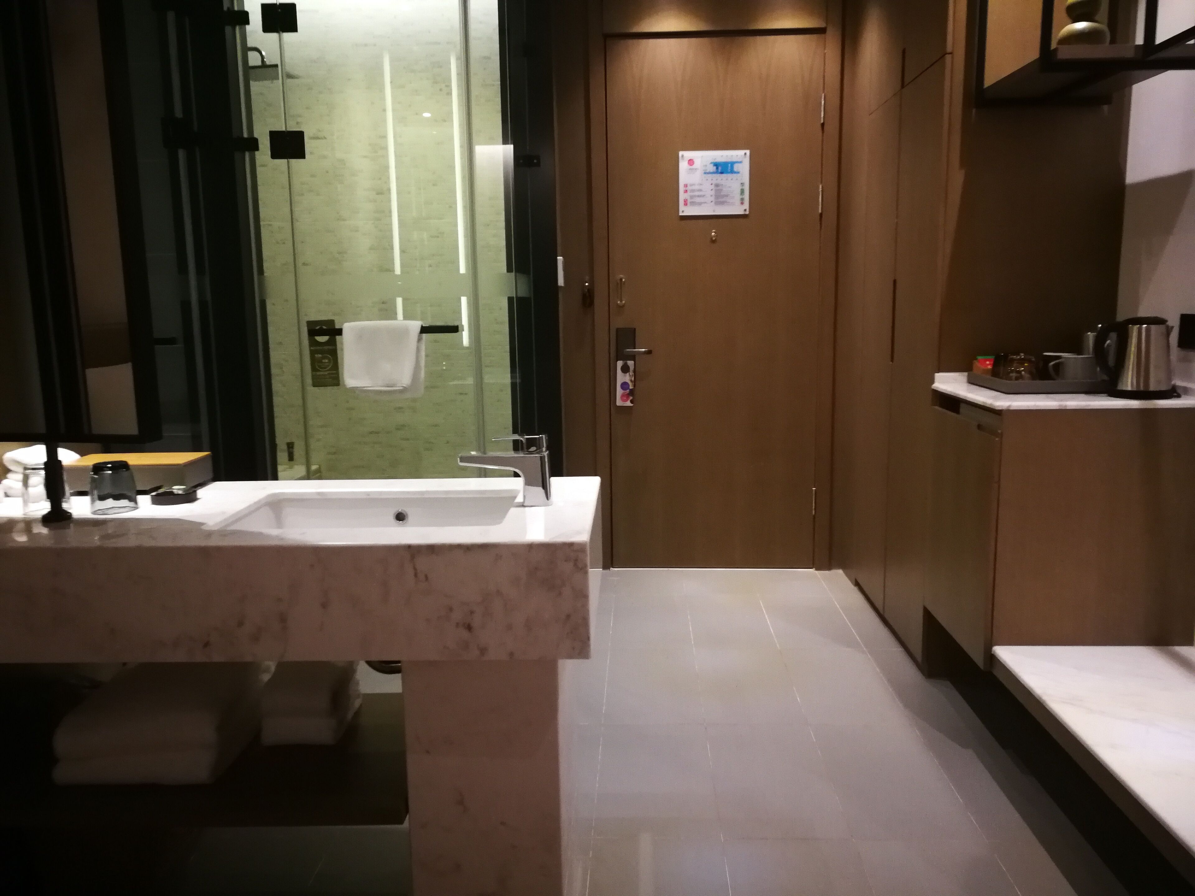 Un baño moderno con lavamanos, espejo y toallero.