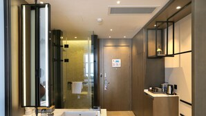 A modern bathroom with a large mirror, a sink, and a shower area. - Novotel Deqing Moganshan (Huzhou)