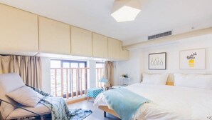 Une chambre moderne avec un grand lit, un canapé et une fenêtre avec des rideaux.