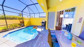 A covered outdoor swimming pool with a hot tub, a patio table with drinks, and a view of the surrounding landscape. - Aco248528 - Festival Resort - 5 Bed 5.5 Baths Townhome (Davenport)