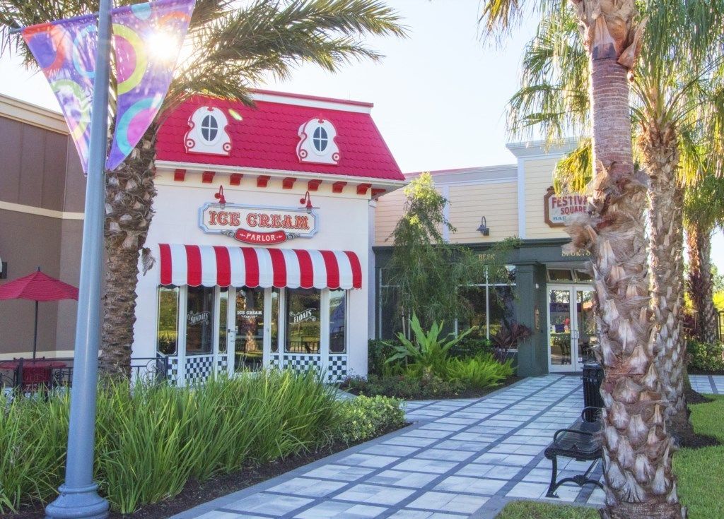 An ice cream parlor with a red and white striped awning and a red roof.