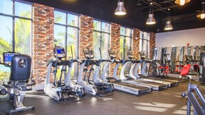 A gym with treadmills, ellipticals, and weight machines, large windows, and a brick wall. - Aco248528 - Festival Resort - 5 Bed 5.5 Baths Townhome (Davenport)