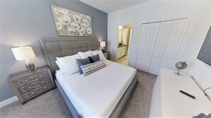 A bedroom with a large bed, a nightstand with a lamp, a dresser, and a mirror. - Aco248528 - Festival Resort - 5 Bed 5.5 Baths Townhome (Davenport)