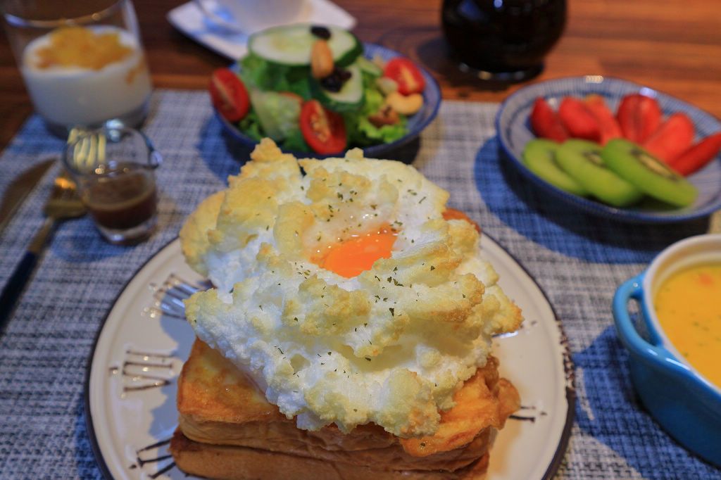 A breakfast plate with scrambled eggs, toast, and a side salad.