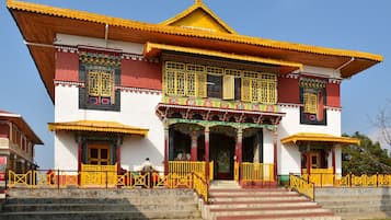 A traditional building with a steeply pitched roof, ornate wooden balconies, and a central entrance with a decorative archway.