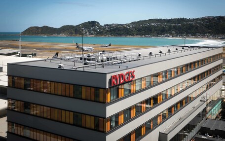 A modern building with the name 'RYDGES' prominently displayed. It features multiple floors with large windows and a flat roof.
