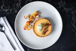 A dessert on a white plate with a dark marble background.