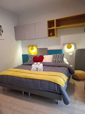 Une chambre à coucher moderne avec un lit, une tête de lit, des tables de chevet et une étagère intégrée au-dessus du lit.