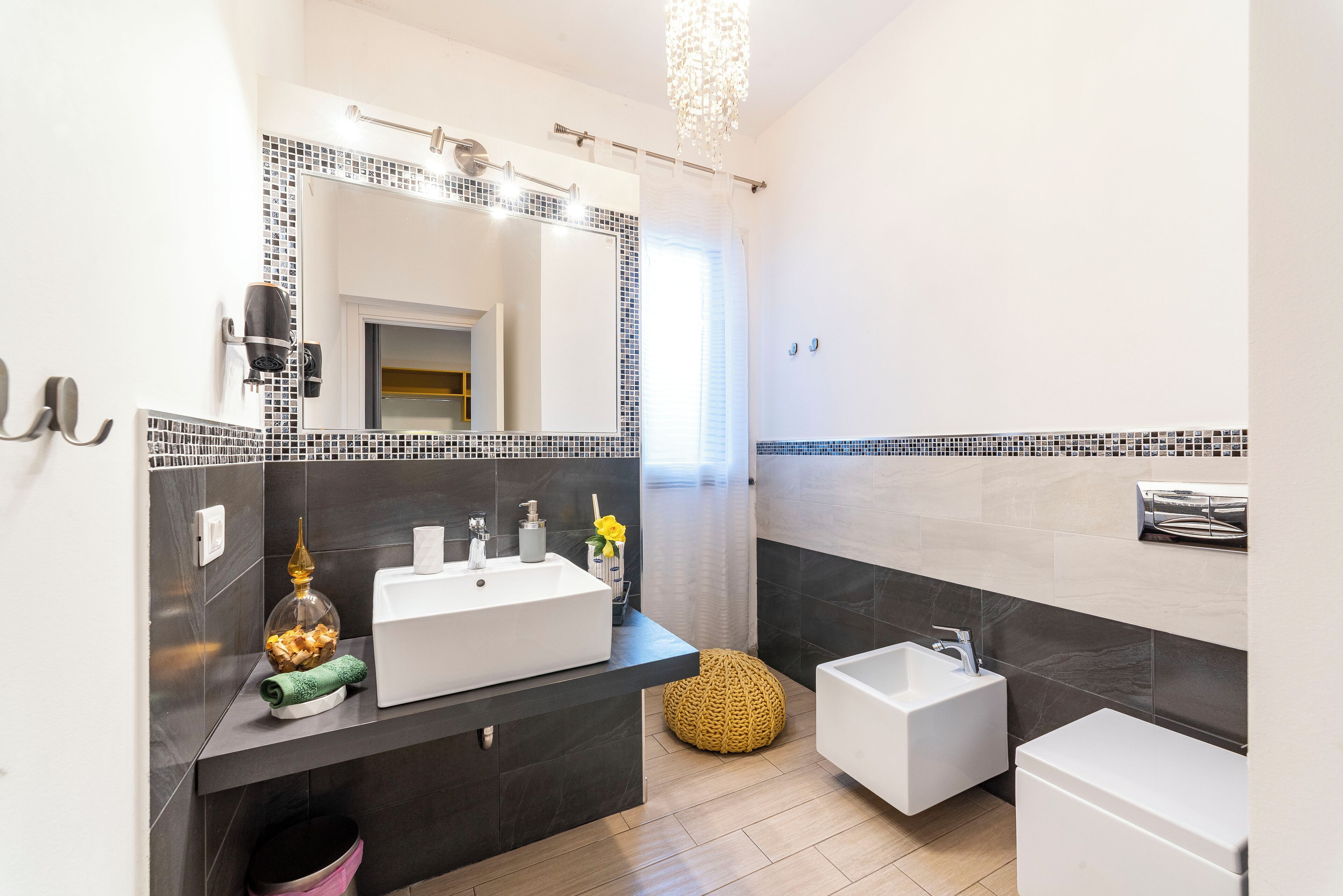 Une salle de bain moderne avec un grand miroir, deux lavabos, des toilettes et un espace douche.