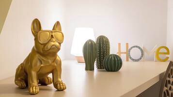 A gold dog figurine, a lamp, and decorative cacti on a white shelf.