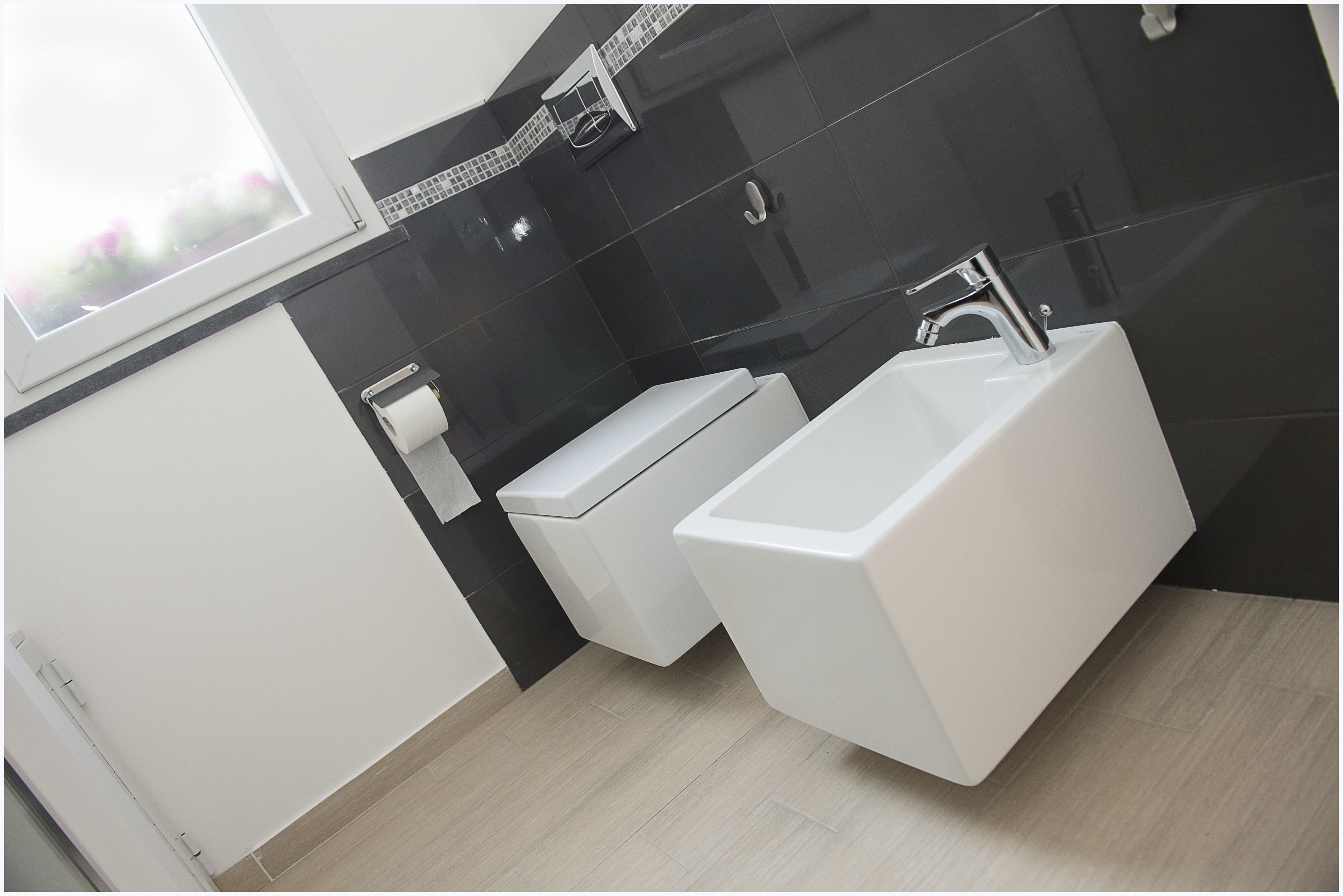 A modern bathroom with a white sink, a toilet, and a bidet.