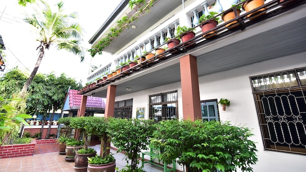 A multi-story building with balconies, potted plants, and a tiled courtyard. - Nong Apartment Pattaya - Adults Only (Pattaya)