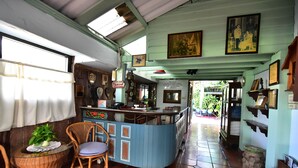 A cozy room with a blue counter, wicker furniture, and a tiled floor. - Nong Apartment Pattaya - Adults Only (Pattaya)