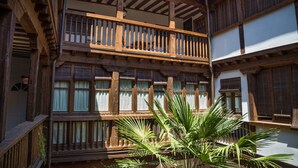 A traditional building with a wooden balcony and multiple windows. - La casa de los Infantes by Toledo AP (Toledo)