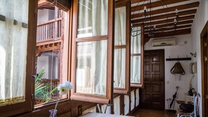 A wooden interior with a large window, a wooden table, and a chair. - La casa de los Infantes by Toledo AP (Toledo)