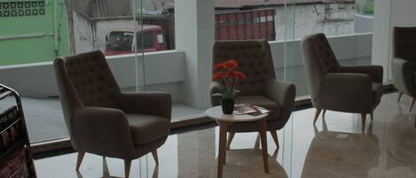 A modern interior with two armchairs and a small table with a potted plant.