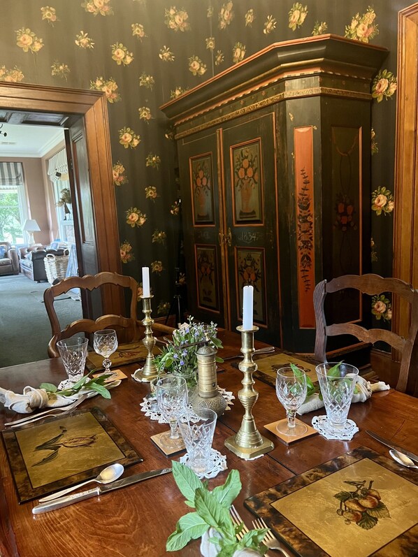 A dining table set with glassware, cutlery, and a centerpiece.