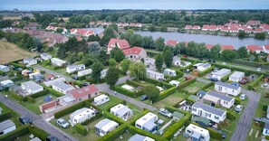 Zona residencial con varias casas móviles y viviendas, un río al fondo y un cielo despejado.