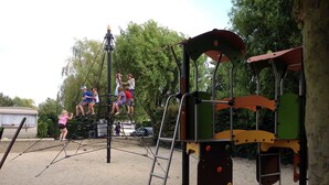 Une aire de jeux avec une structure d’escalade et une balançoire.