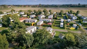 Un parc de maisons mobiles doté de logements compacts, de pelouses verdoyantes et d’une route centrale.