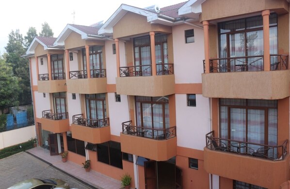 Un immeuble à plusieurs étages, doté de balcons, de grandes fenêtres et d’un toit plat.