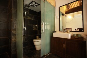A bathroom with a glass-enclosed shower, a white toilet, a wooden vanity with a mirror, and a white sink. - Beijing Shiguang Greatwall Boutique Inn (Yanqing)