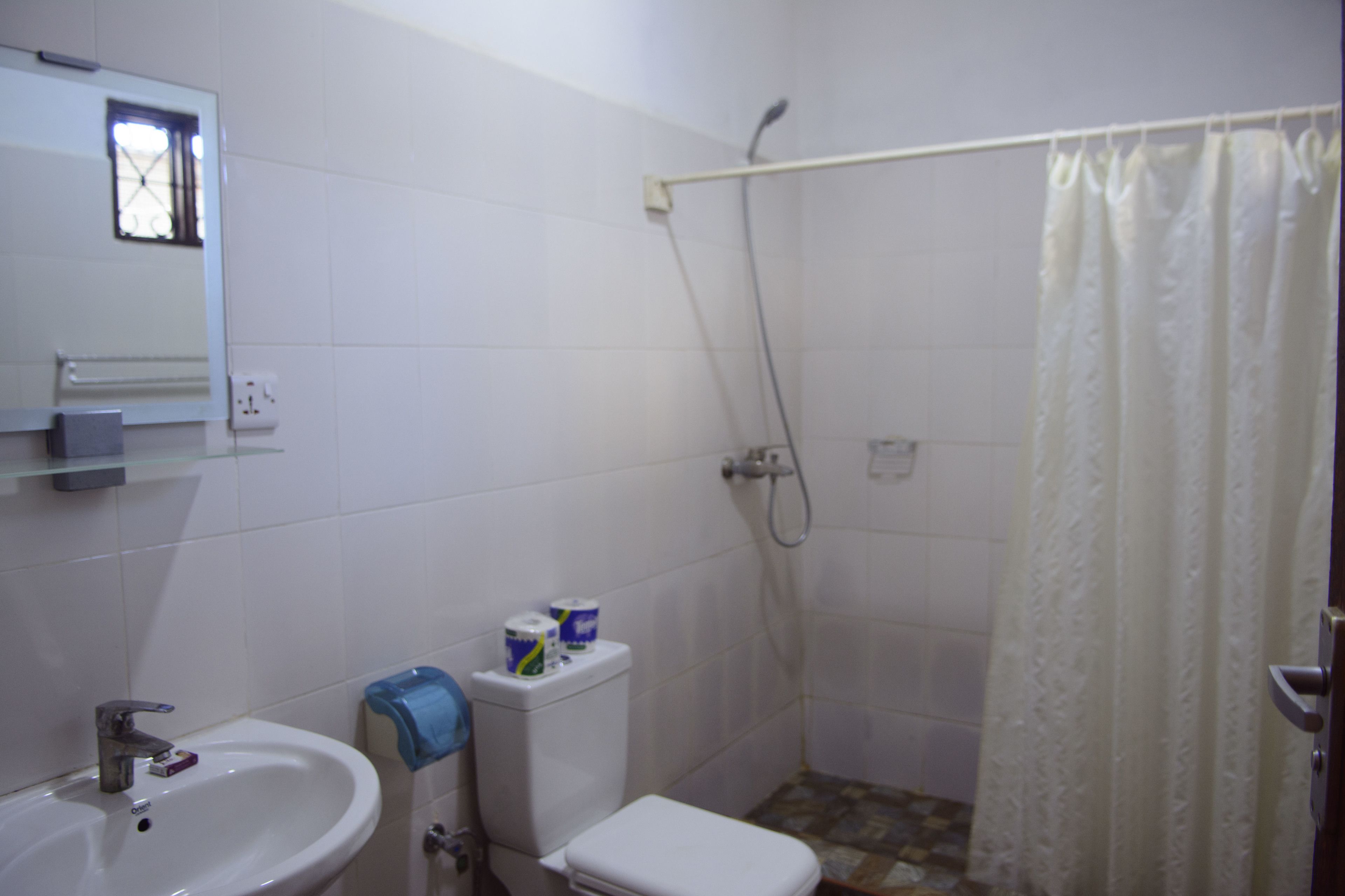 Ein Badezimmer mit Waschbecken, Toilette und Duschbereich.