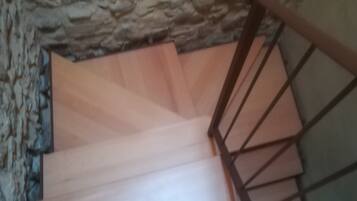 A wooden staircase with a stone wall background.