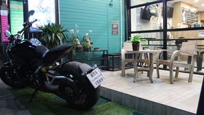 Une moto était garée devant un café, et une pancarte indiquait qu’elle était réservée aux clients de l  ’établissement.