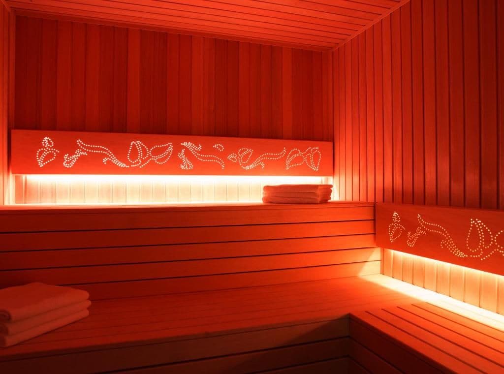 A sauna with wooden slats and a heated bench.