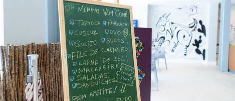 A chalkboard menu in a restaurant with various food items listed.