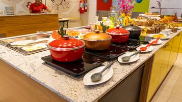 Montaje de bufé con diversos alimentos y equipo de cocina.