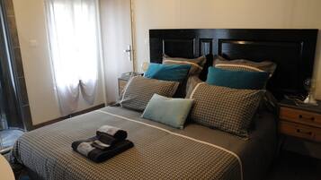 Une chambre d’hôtel avec un lit, une table de chevet, une lampe et une fenêtre avec des rideaux.