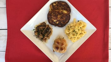 A white plate with food on a red placemat.