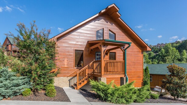 A wooden cabin with a porch, staircase, and a view of the surrounding landscape. - The Game Changer! Next to Dollywood/Hot-Tub/Pool/LUXURY (Pigeon Forge)